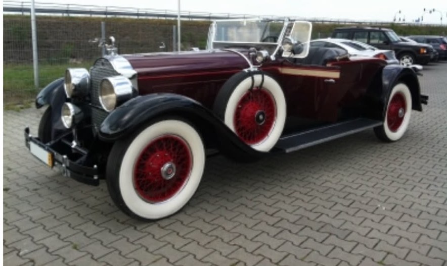 Weinroter Oldtimer-Roadster mit roten Speichenfelgen nach der Aufbereitung